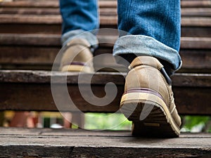 Adult man walking up the wooden stairs. Moving forward Concept.