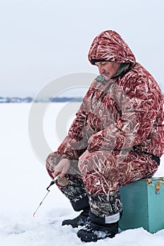 Adult man winter fishing