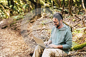 Adult man work outdoor with laptop computer - concept of digital nomad smart work job and free from office modern people -