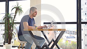 Adult man working on laptop sitting in openspace office