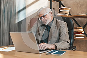 Adult man at the workplace, an important telephone conversation. Retired work, mature entrepreneur