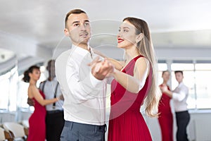 Adult man and young woman dancing waltz