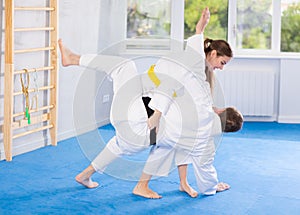 Adult man and young woman training judo fight