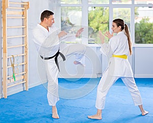 Adult man and young woman training karate fight