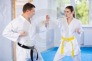 Adult man and young woman training karate fight