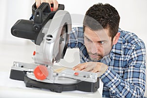 adult master sawing platband with circular saw indoors