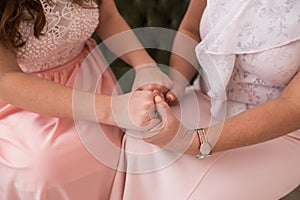 Adult mom and daughter holding hands