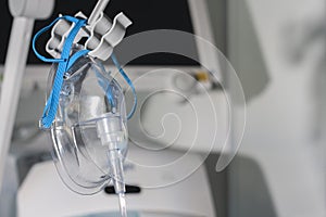 Adult oxygen face mask, on background medical ventilator in ICU in hospital