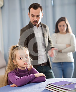 Adult parents lecturing girl for bad behavior