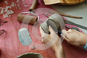 Adult potter master cutting the clay on table. Top view, closeup, hands only. Art and business, hobby and freelance