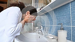 Adult pregnant woman washing face during daily morning beauty procedures. Hygiene and purity concept