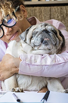 Adult pretty young woman work at laptop computer and hug her adorable dog - happy female working online with internet connection