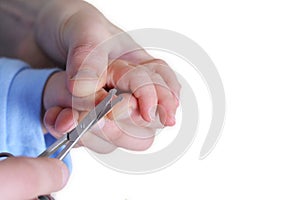 AdultÃÂ´s hand is cutting childÃÂ´s nails photo