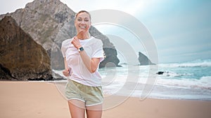 Adult smiling woman jogging on beach