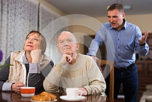Adult son argues with his elderly parents at home