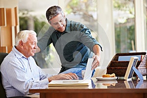 Adult Son Helping Father With Laptop