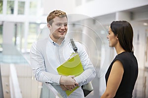 Adult student and teacher talking in university foyer