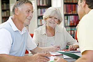 Adult students working together in a library