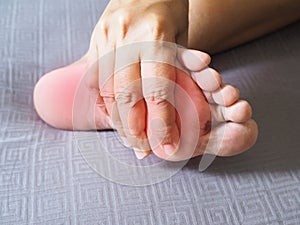 Adult thai woman suffering with foot pain, sore feet and numbness