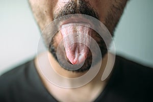 Adult unshaven man sticking tongue out