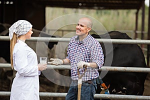 Adult veterinarian chatting with farmer