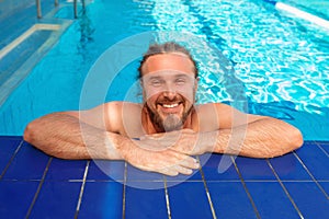 Adult white Caucasian European woman`s legs with orange ultraviolet pedicure underwater in swimming pool.