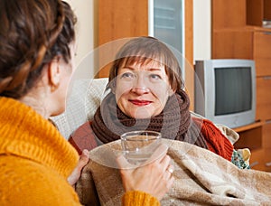 Adult woman caring for unwell senior mother