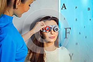 Adult woman checks vision in an ophthalmologist with corrective