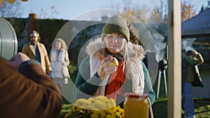 Adult woman chooses apples at the stall