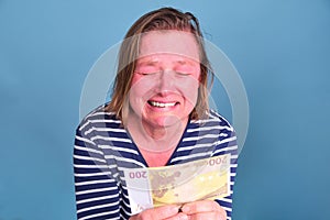 An adult woman cries over a 200 euro bill. Problems with money during the crisis