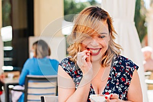 Adult woman eating sweets and smiling, skipping diet. happiness concept with food