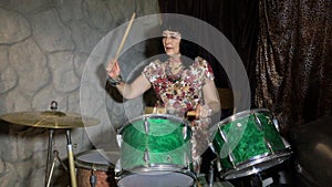 Adult woman has fun, learns to play on an old vintage drum set.