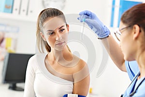 Adult woman having blood collection visit at female doctor`s office