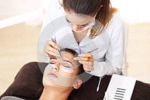 Adult woman having eyelash extension in professional beauty salon