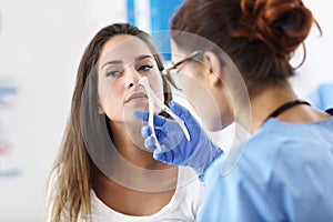Adult woman having a visit at female laryngologist`s office