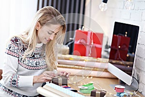 Adult woman at home wrapping Christmas presents