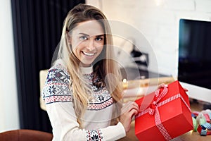 Adult woman at home wrapping Christmas presents