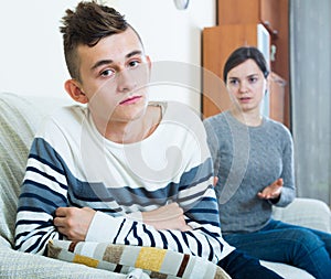 Adult woman lecturing unpleased teenager in home interior