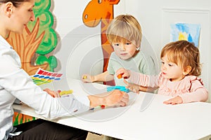 Adult woman with little kids play educative games photo