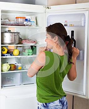 Adult woman looking for eat in refrigerator