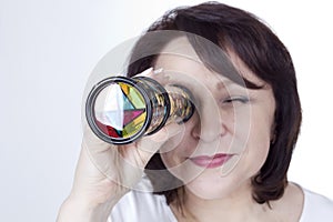 Adult woman looking into a kaleidoscope photo