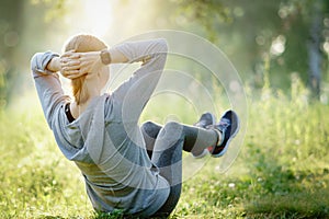 Adult woman performing core crunch exercise. Smartwatch