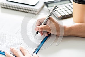 adult woman person hand holding pen writing or signing document on clipboard indoor at company, closeup finger professional