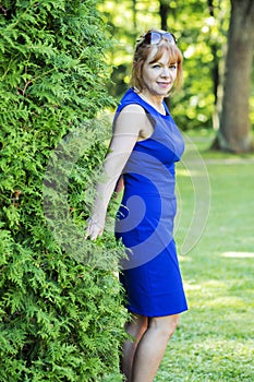 Adult woman poses in the green park