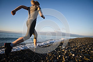 Adult woman runner running on sunrise seaside. Healthy lifestyle