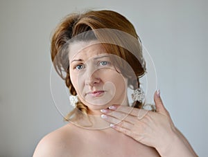 Adult woman with a sore throat on ight background