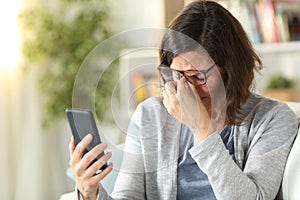 Adult woman suffers eyestrain with eyeglasses at home