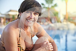 Adult woman sunbathing by the pool