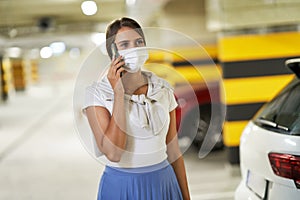 Adult woman using cellphone in underground parking lot