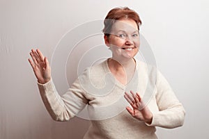 Adult woman on a white background in a light sweater. Emotions